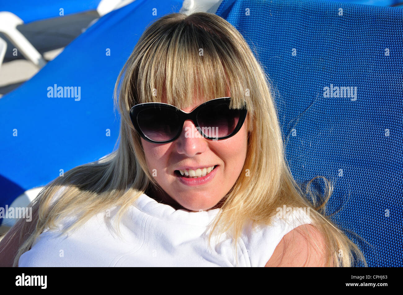 Jeune femme sur les transats, Talayot Apartments, Cala'n Blanes, Minorque, Iles Baléares, Espagne Banque D'Images