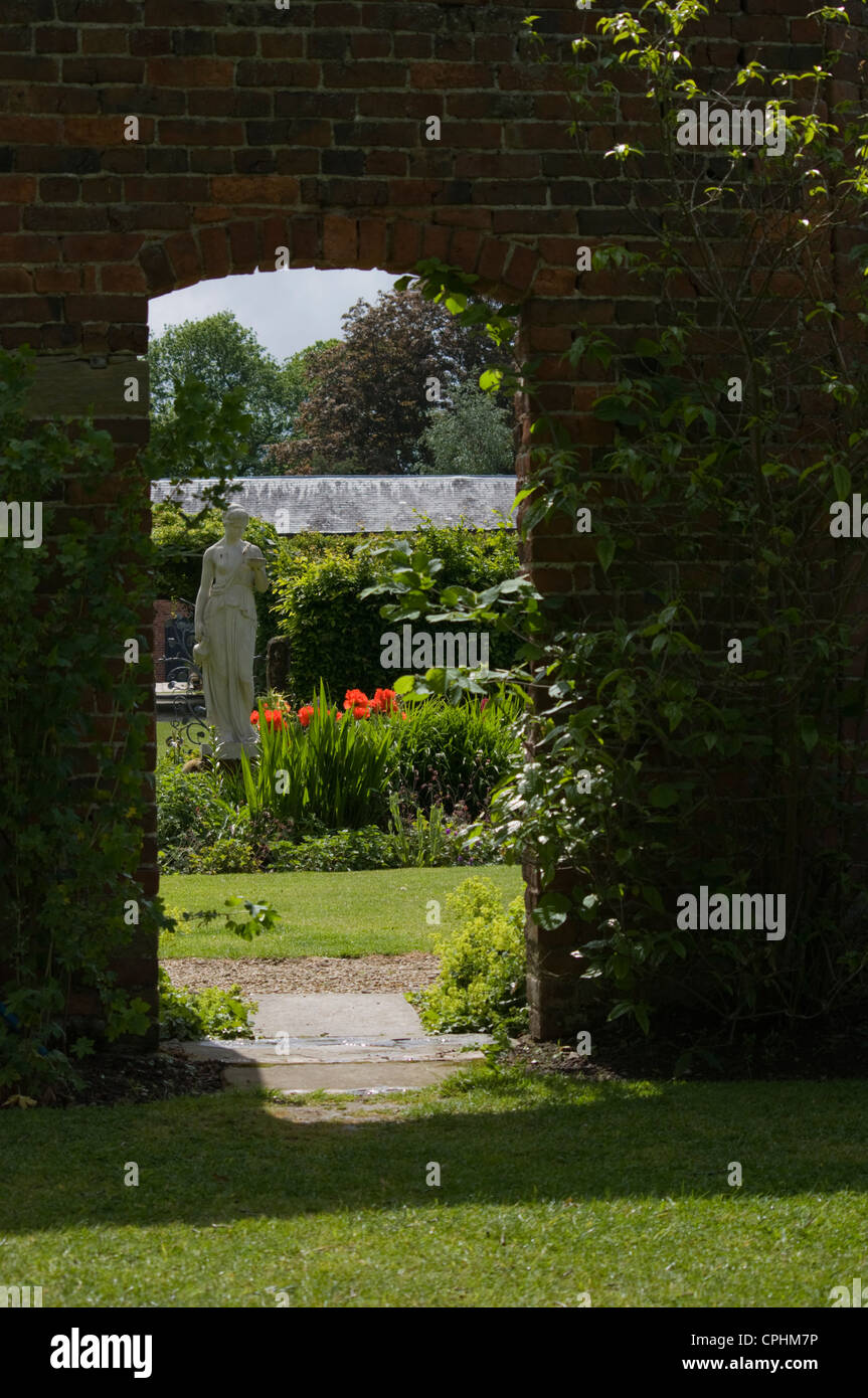 Entrée voûtée d'un jardin clos avec une statue au-delà Banque D'Images