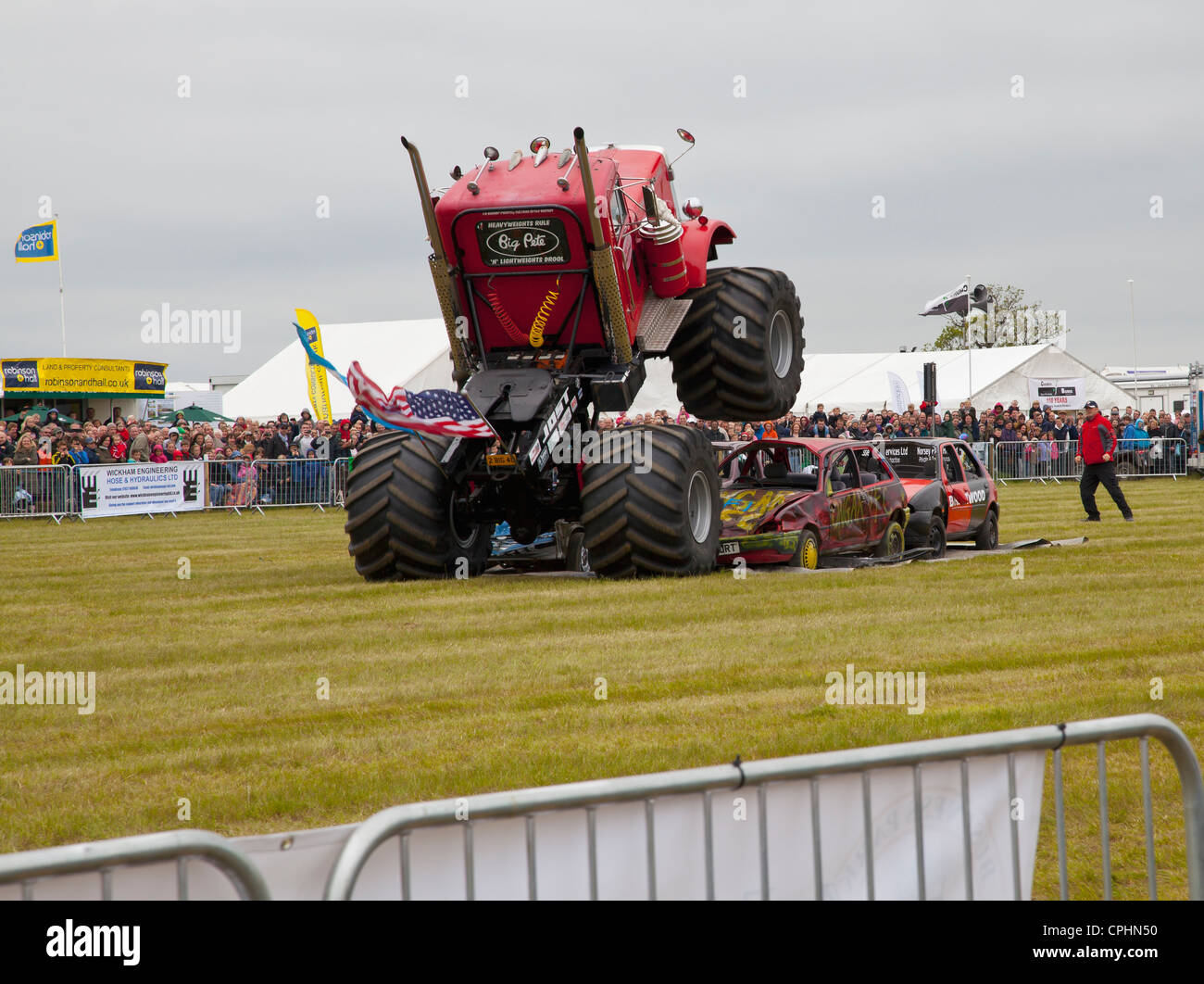 Monster truck sautant des rangées de voitures Banque D'Images