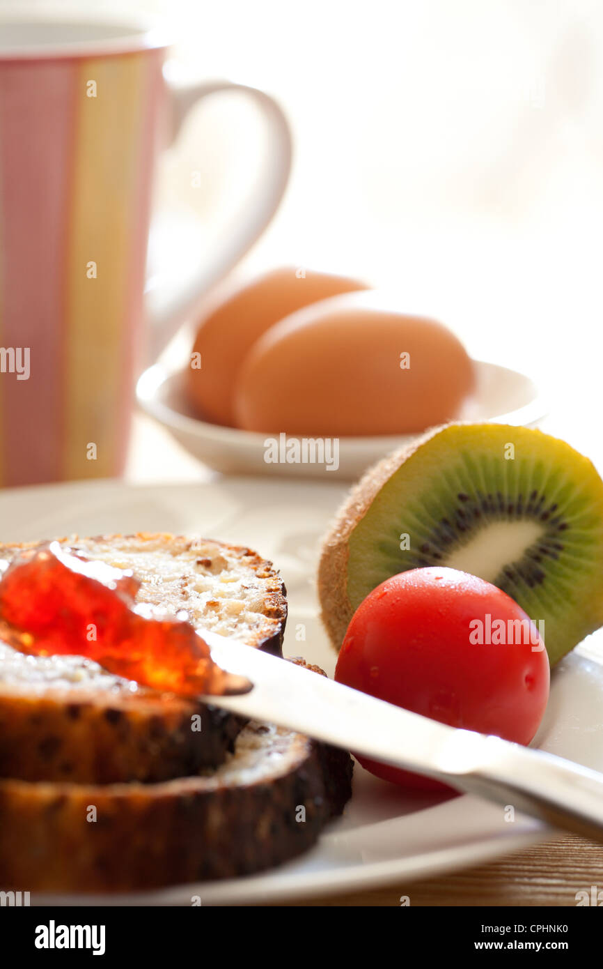 Petit-déjeuner avec du pain de la confiture de tomates cerises Oeufs Kiwi  et un plateau/bouilloire Photo Stock - Alamy