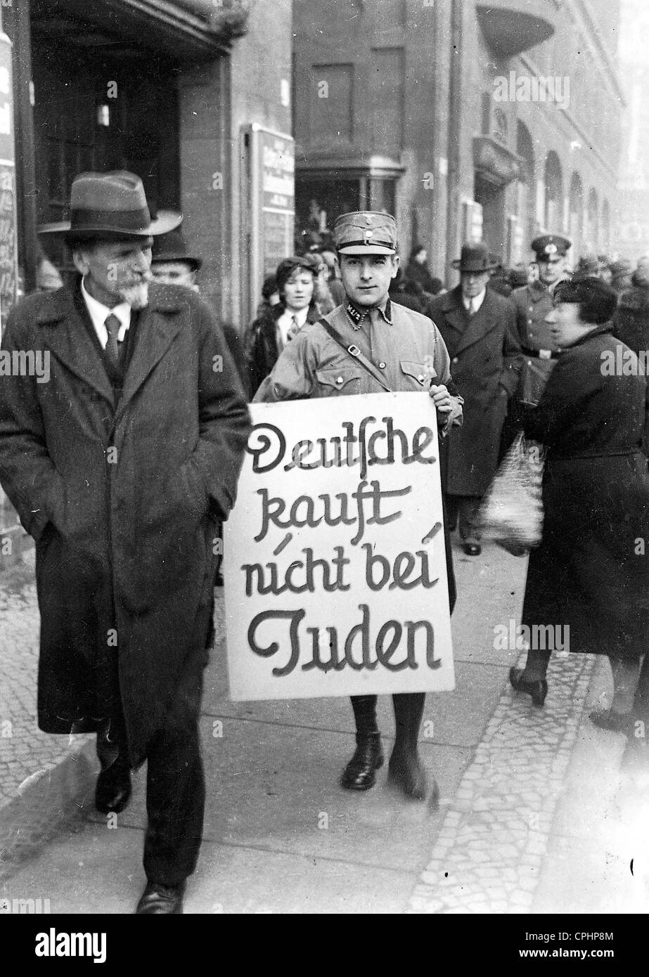 Un agent de sa porte un signe par Berlin, encourageant les citoyens à boycotter les magasins juifs, Berlin, 1er avril 1933 (photo n/b) Banque D'Images