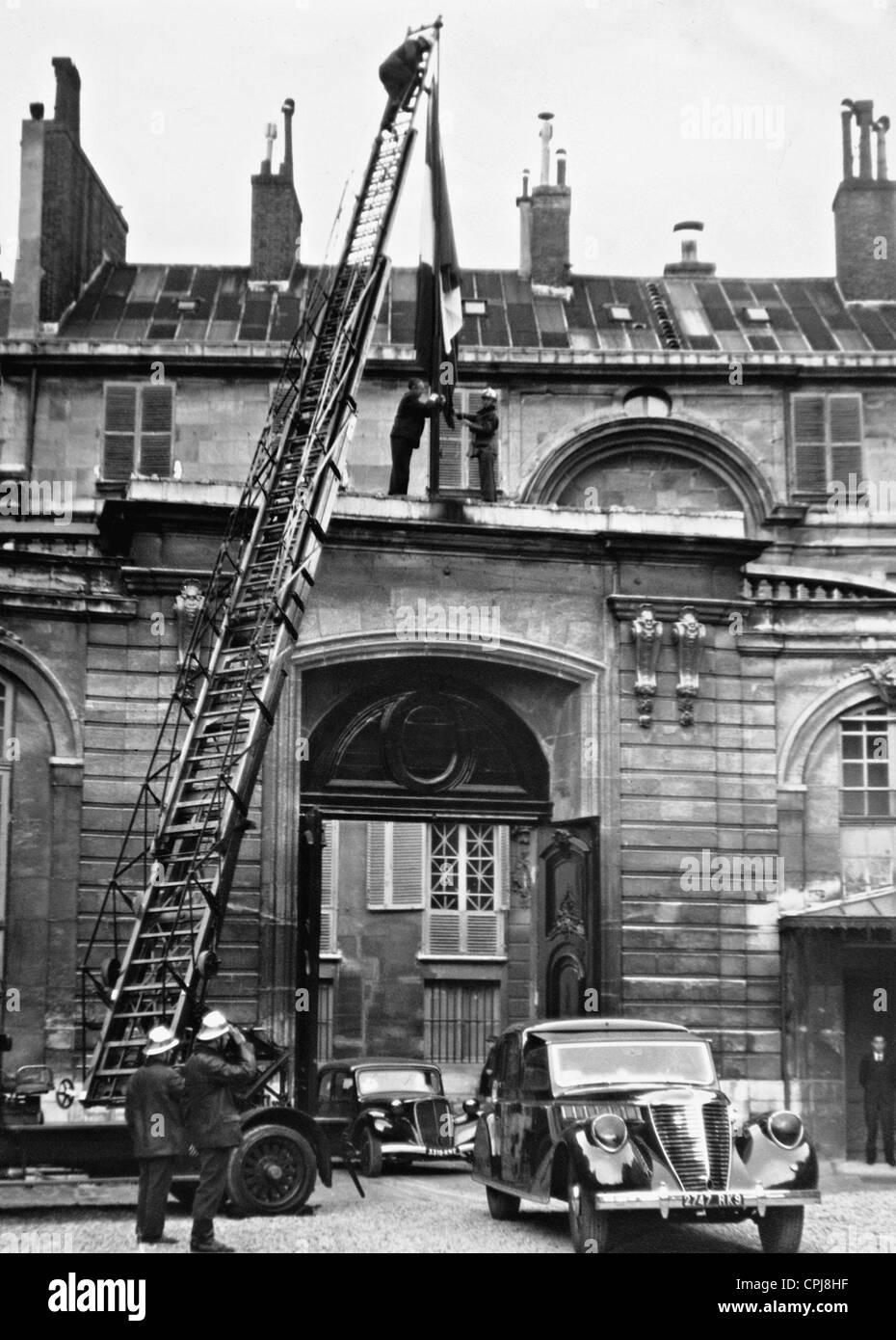 Les pompiers sont un drapeau national français de levage sur l'Hôtel Matignon, 1942 Banque D'Images