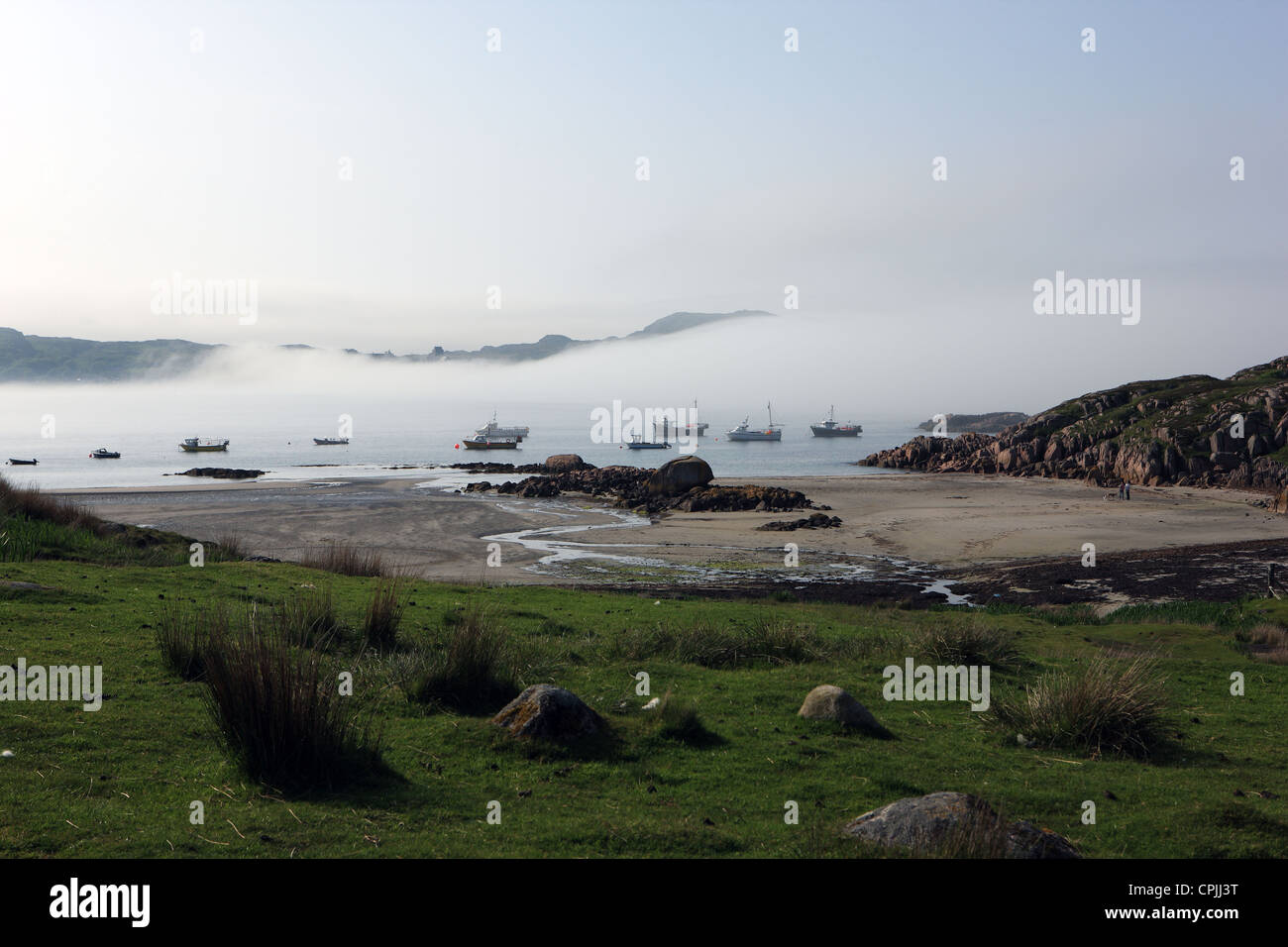 Bateaux de pêche englouti comme sea mist roule dans le son d'Iona sur une très chaleureuse et ensoleillée Banque D'Images