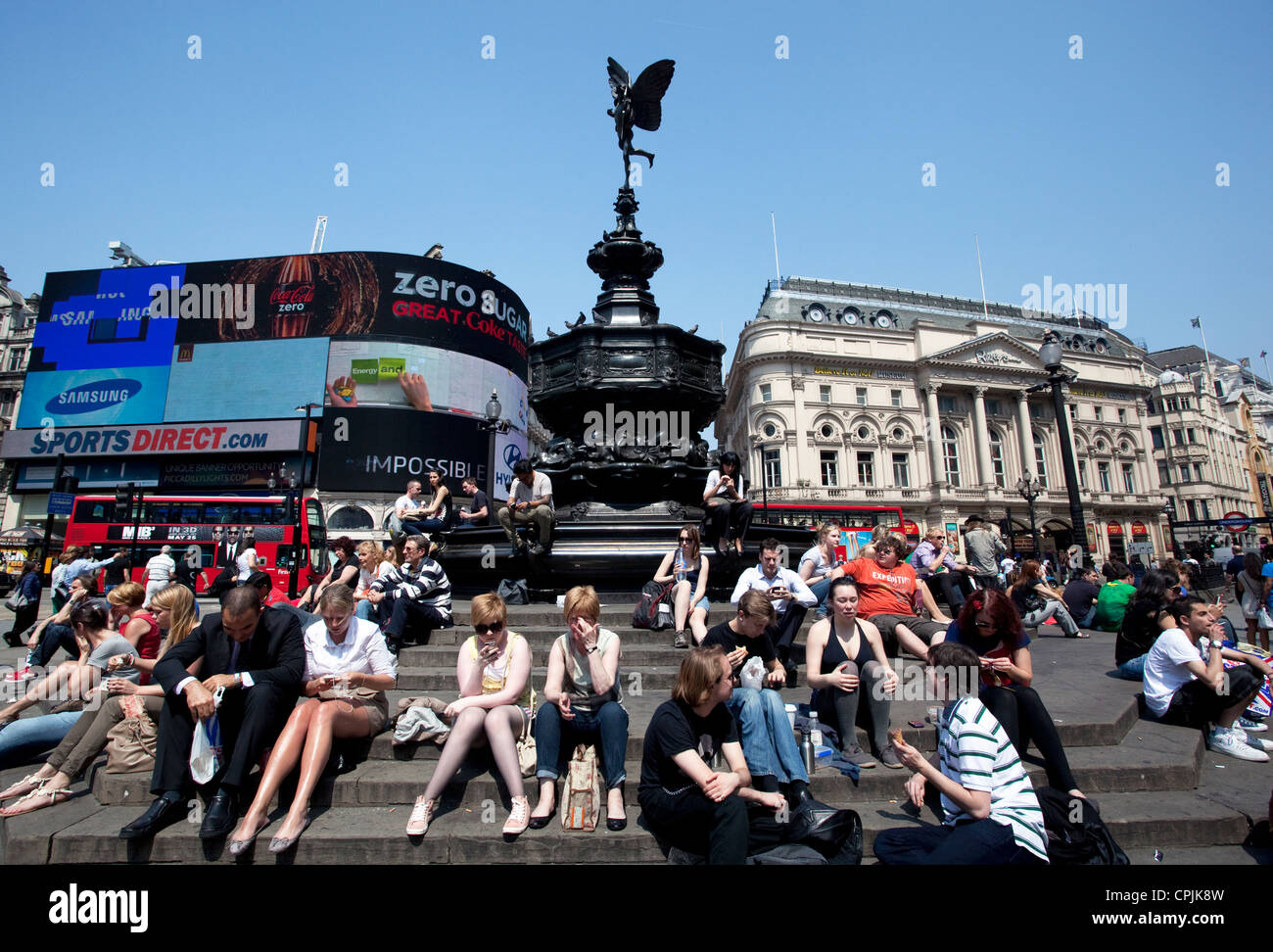 Les touristes peuvent profiter du soleil dans Piccadilly Circus, Londres Banque D'Images