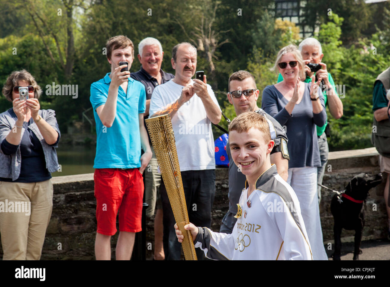 Matty portant le Clarke London 2012 Olympic Torch à travers Ludford Bridge, Ludlow, Shropshire le 24 mai 2012 Banque D'Images