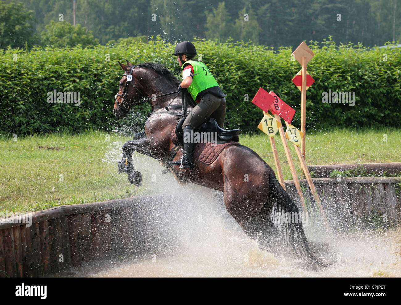 Horse Rider saute un obstacle d'eau lors d'un concours complet de trois jours Banque D'Images