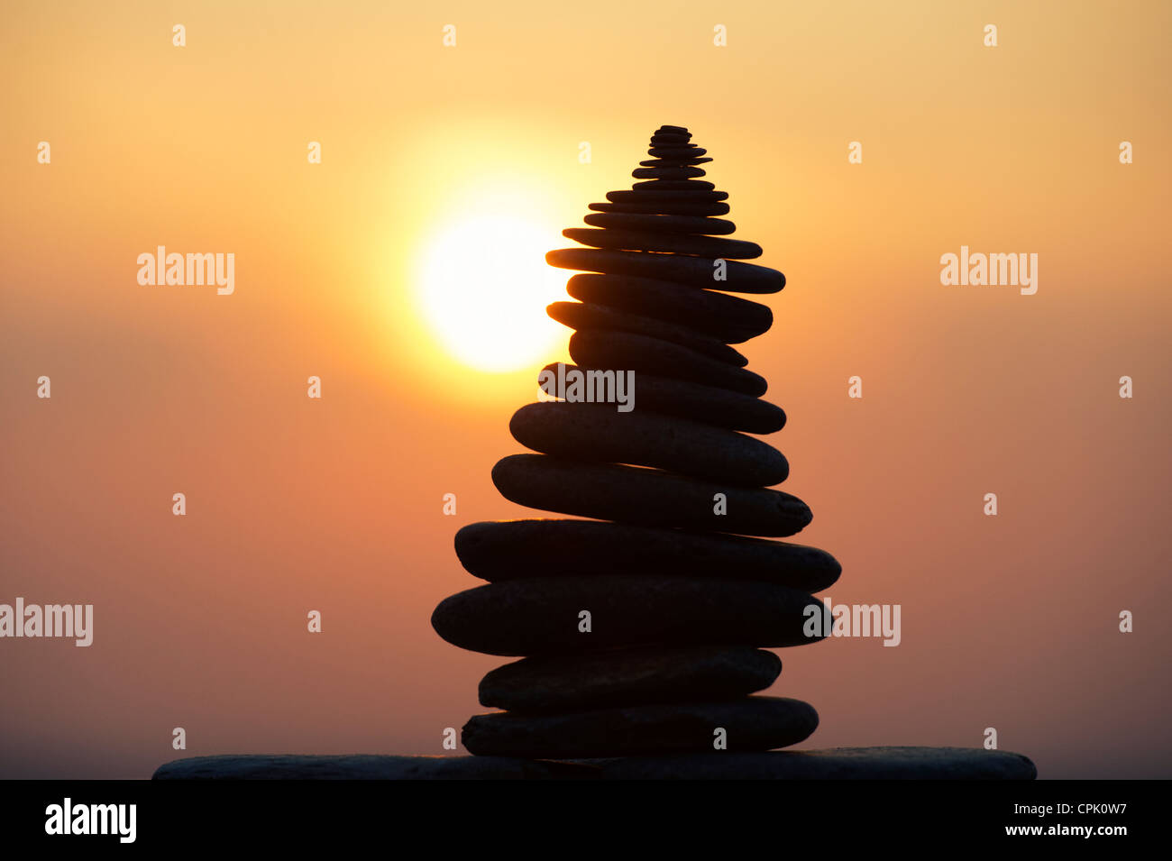 Galets empilés contre une silhouette au coucher du soleil. UK Banque D'Images