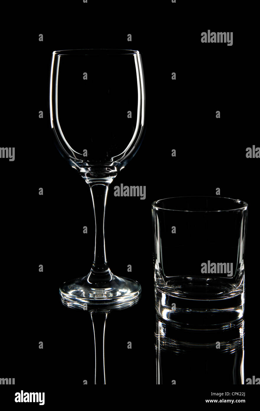 Verre à vin et verre de whisky silhouette sur un fond noir avec reflet Banque D'Images