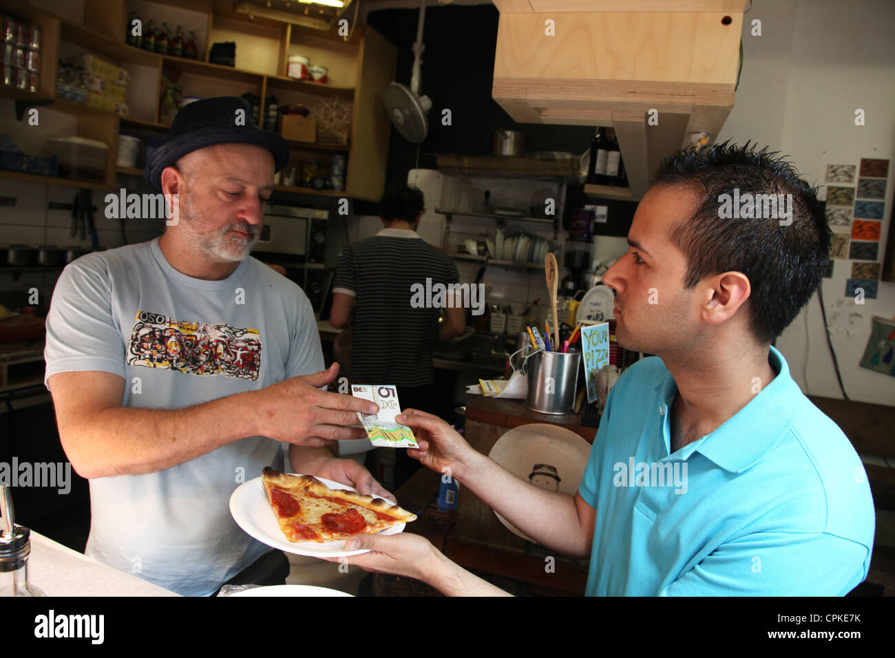 Un client paie pour un délicieux repas dans un restaurant à la brixton Pound, une monnaie de rechange visant à stimuler l'économie locale. Banque D'Images