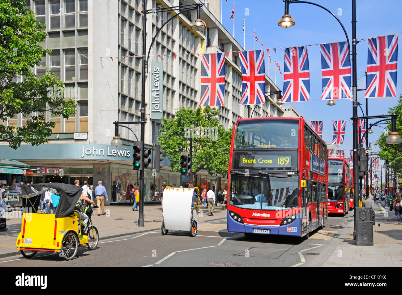 Rickshaws et bus rouges à l'extérieur du grand magasin John Lewis Oxford Street Union Jack flags Queens Diamond Jubilee & 2012 Olympic Jeux Londres Angleterre Royaume-Uni Banque D'Images