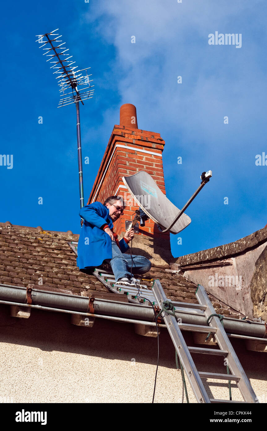 Technicien de télévision antenne satellite fixation sur chambre cheminée -  France Photo Stock - Alamy