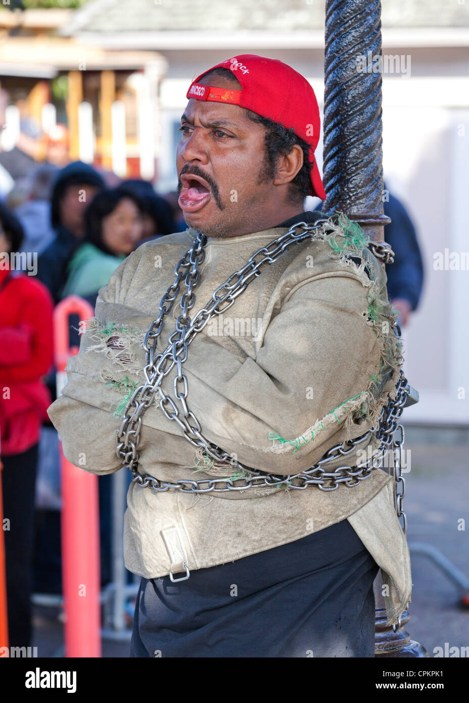 Un artiste de rue s'échapper à la chaîne pour un poteau - San Francisco, California USA Banque D'Images