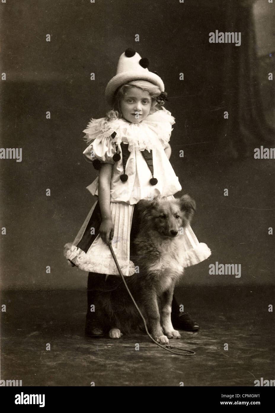 Petit Clown Fille essayant de monter un petit chien Banque D'Images