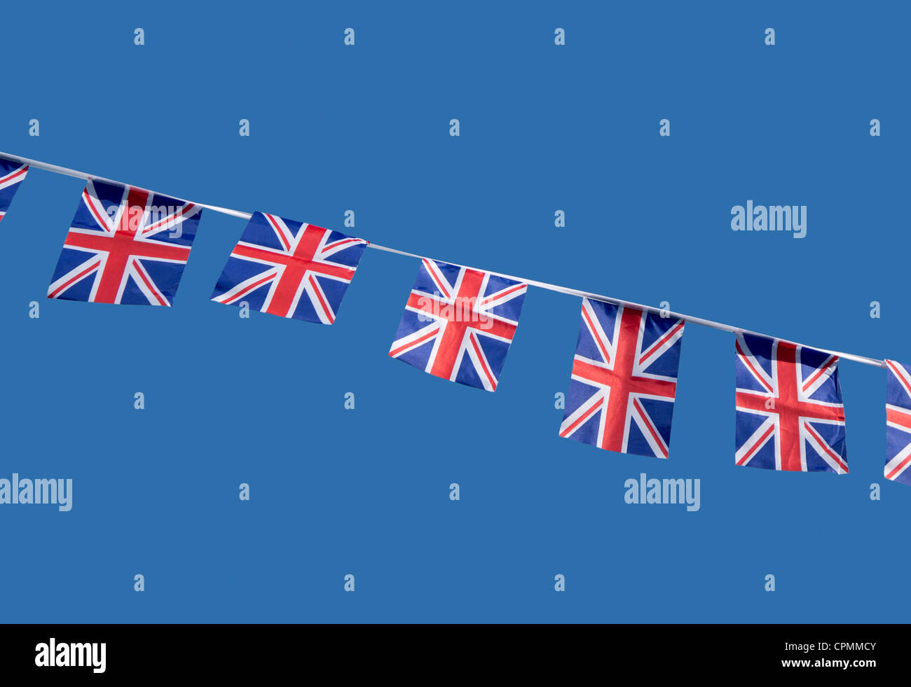 Les petits British Union Jack drapeaux célébration contre un ciel bleu. Banque D'Images