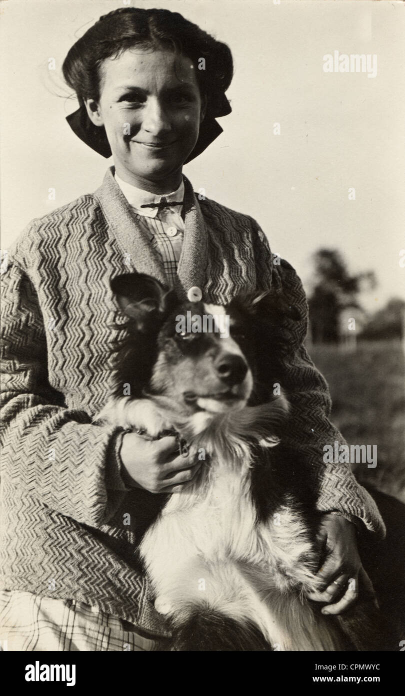 Souriante jeune fille dans un chandail Holding her Collie Banque D'Images