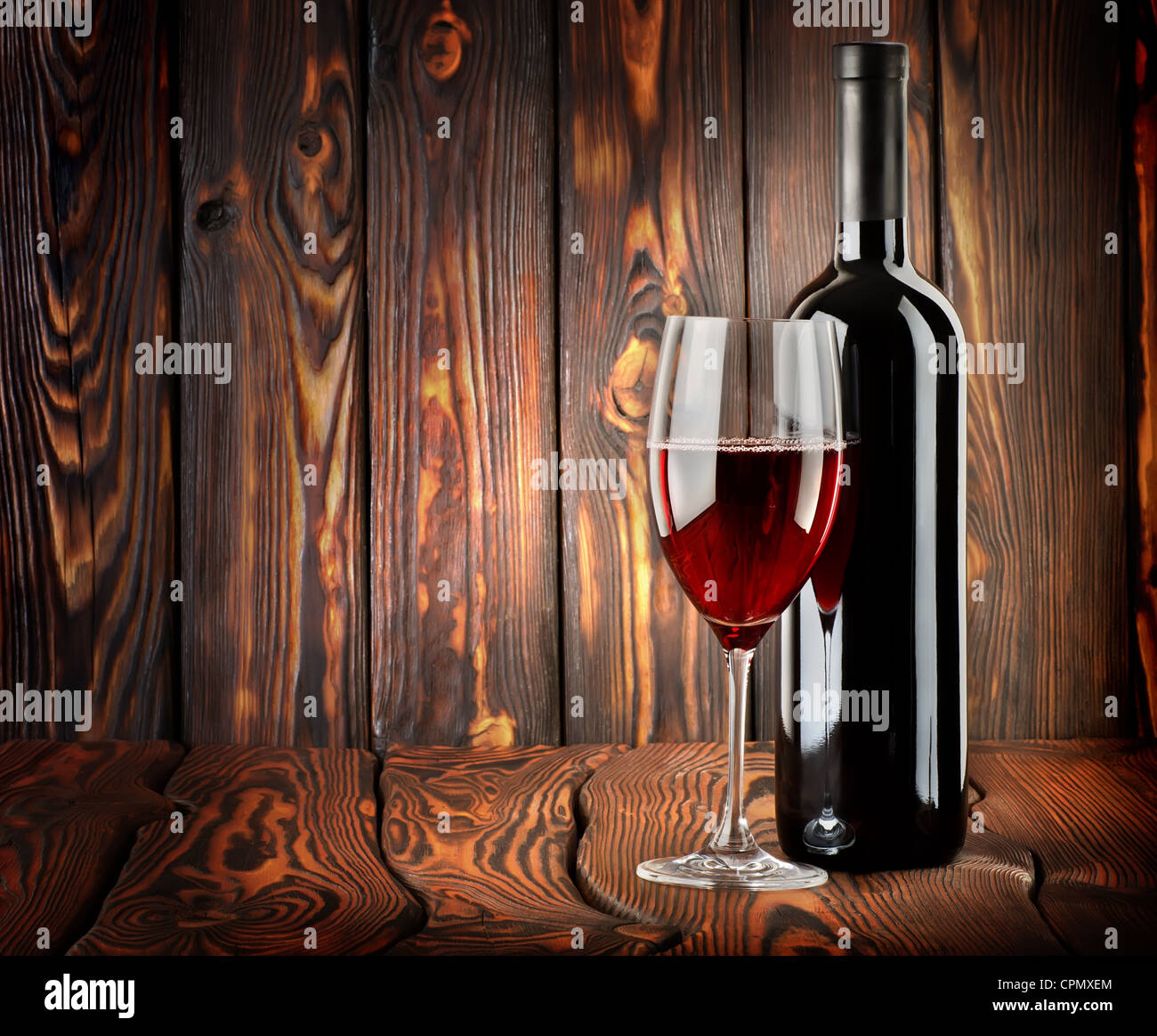 Vin rouge avec un verre de vin sur fond de bois Banque D'Images