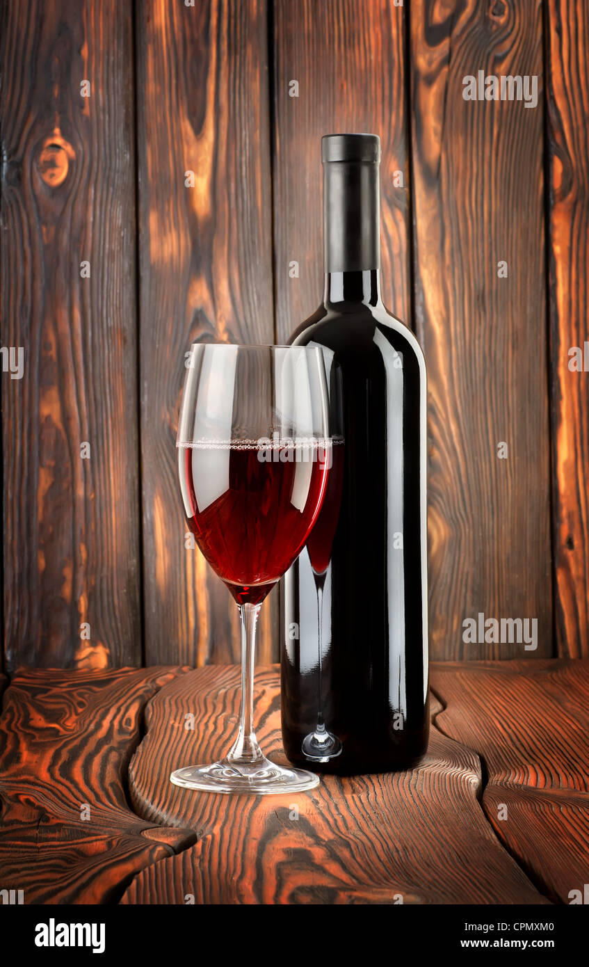 Vin rouge avec un verre de vin sur fond de bois Banque D'Images