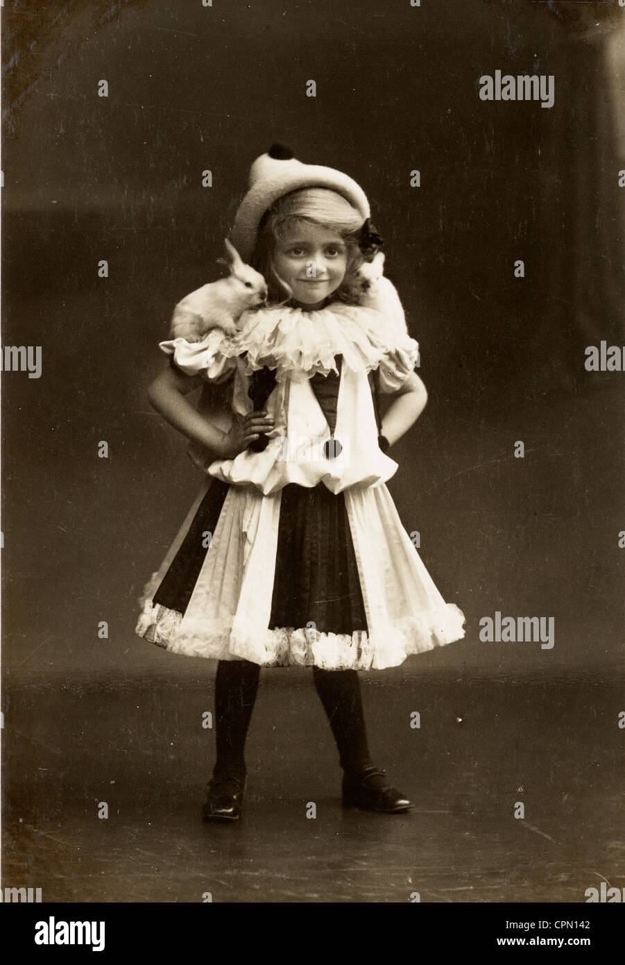 Petite fille en Costume Clown avec bébés lapins perchés sur ses épaules Banque D'Images