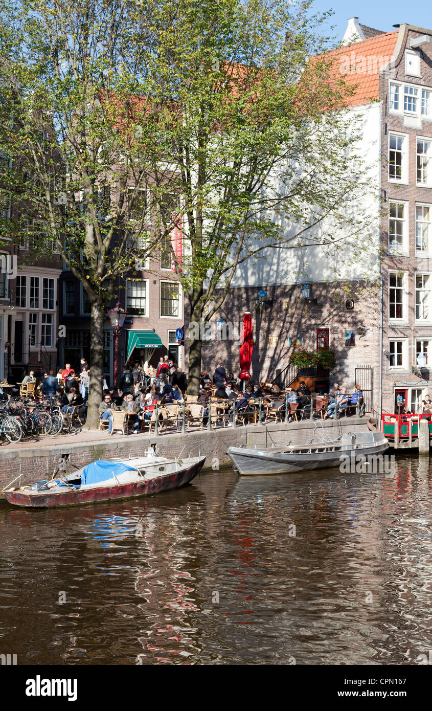 Un dimanche après-midi ensoleillé dans un café au bord du canal sur le Oudezijds Voorburgwal à Amsterdam. Banque D'Images