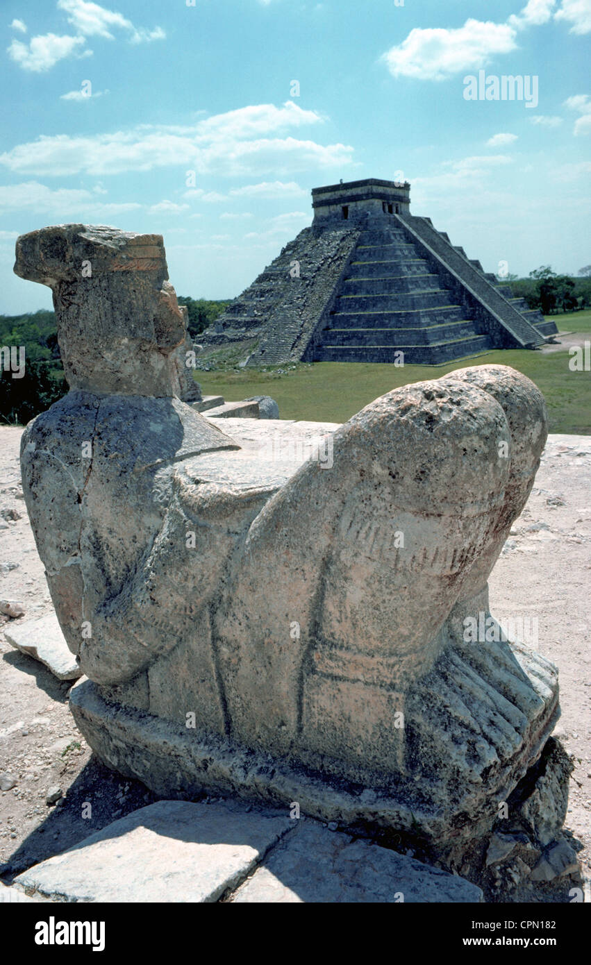 Une statue de pierre de Chac-Mool se retourne vers le château de Kukuclan pyramide-étape dans les ruines mayas de Chichen Itza sur la péninsule du Yucatan au Mexique. Banque D'Images