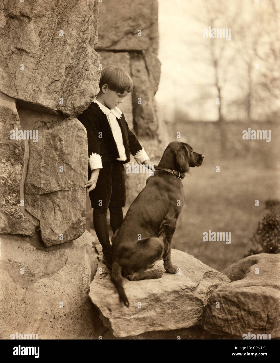 Jeune garçon riche avec chien de chasse sur les rochers Banque D'Images