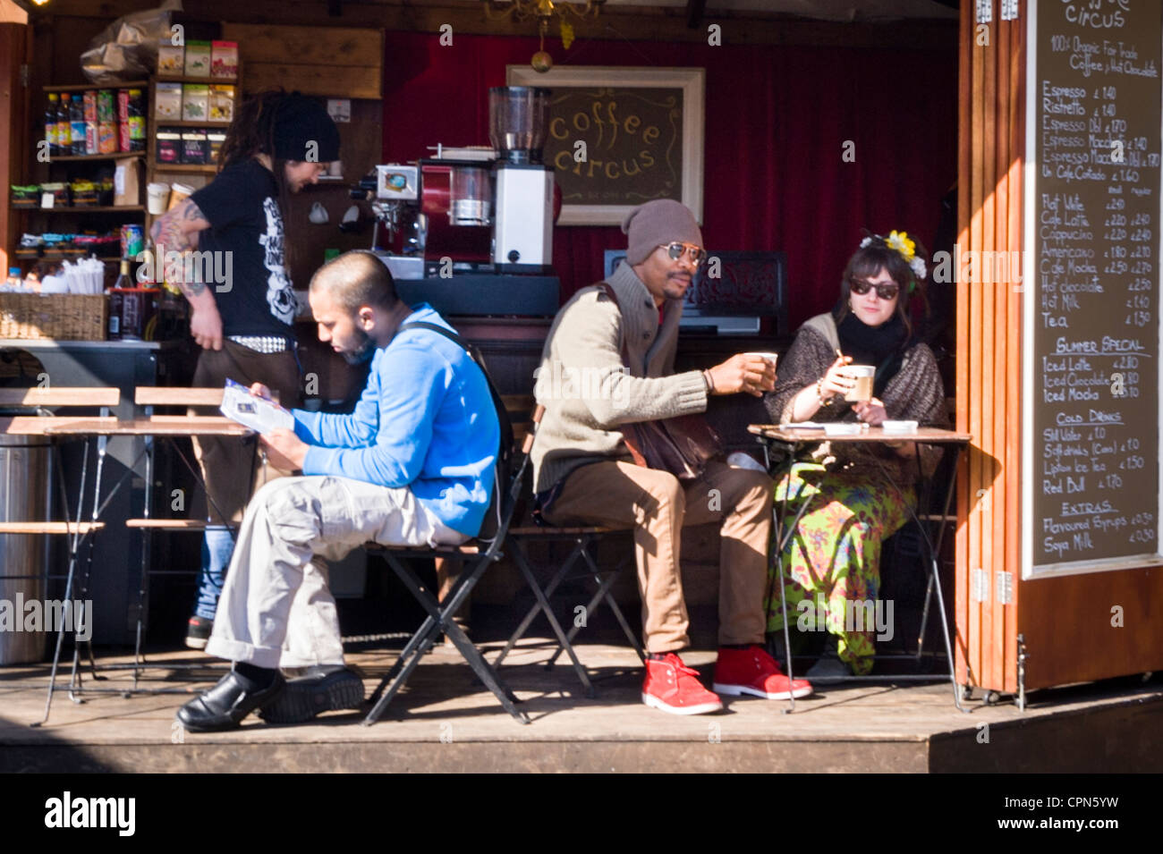 London Camden Town Village Market Cirque café café restaurant snack-bar des gens intéressants sur des tables tables chaises cheveux fleur tatouages Banque D'Images