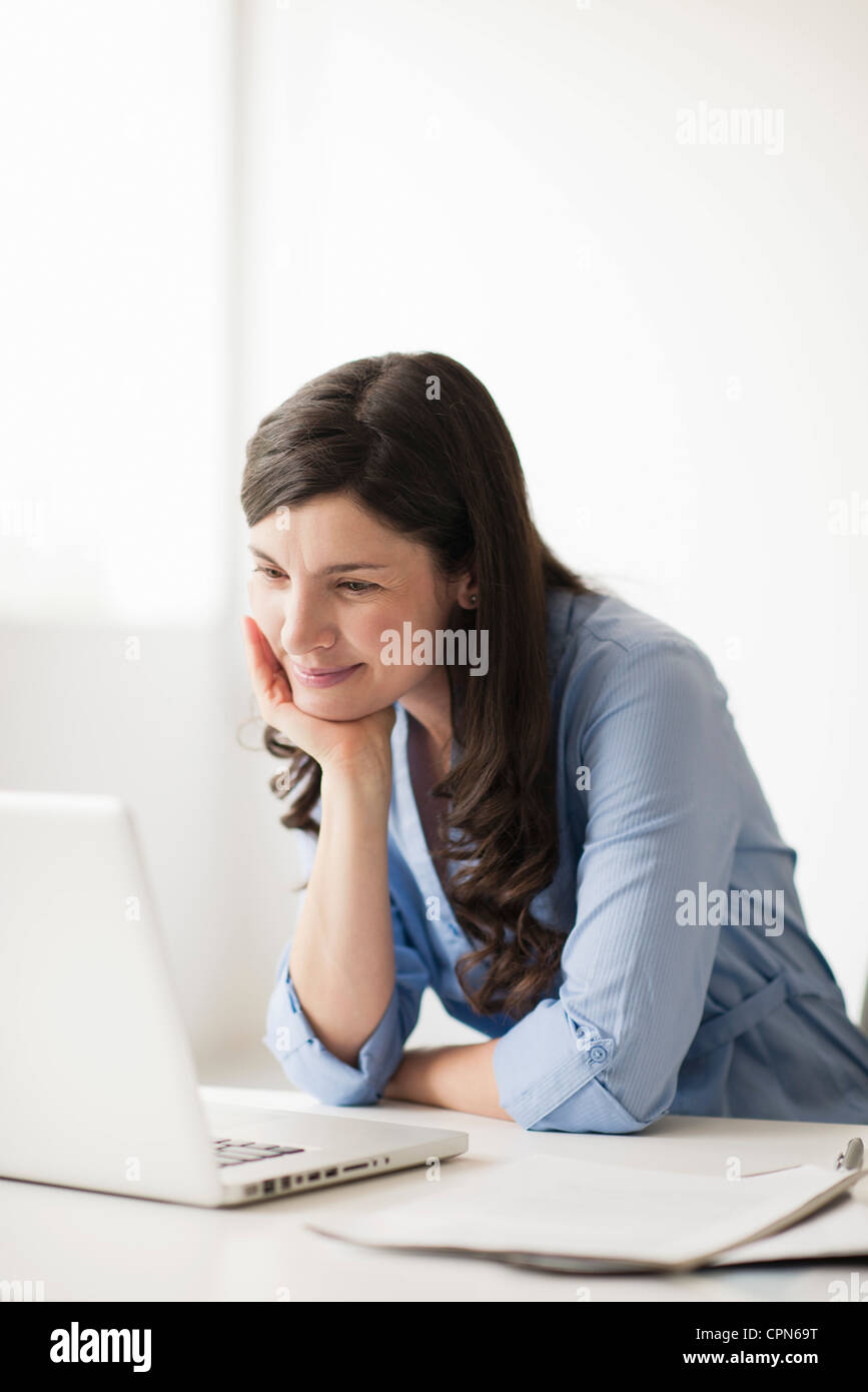 Mid-adult woman using laptop computer Banque D'Images
