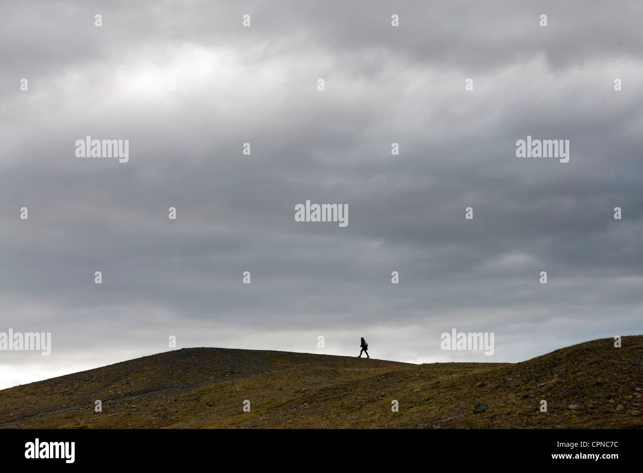 L'Islande, personne à marcher le long d'une colline dénudée Banque D'Images