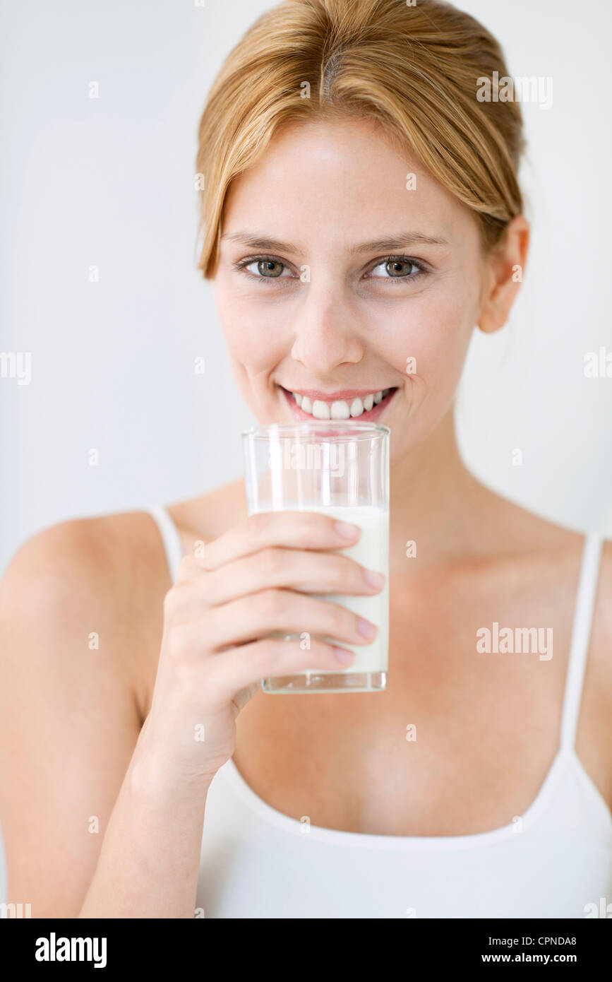 Jeune femme tenant un verre de lait Banque D'Images