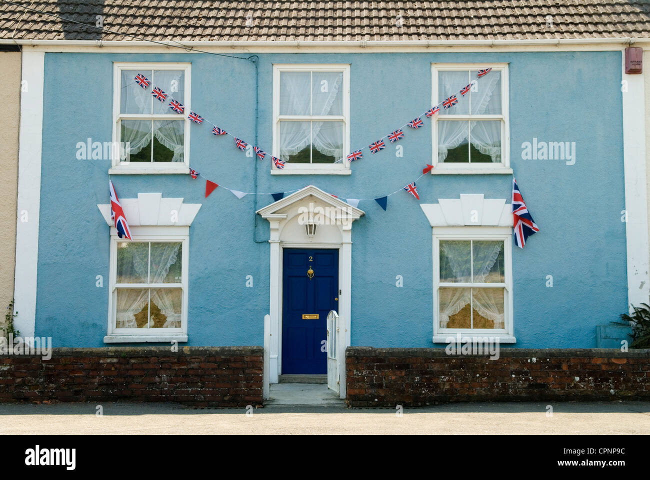 Drapeau de l'Union Jack volant, banderole flottant décorant le devant d'une maison, Axbridge, Somerset en préparation du Jubilé de diamant de la Reine. Angleterre des années 2012 2010 Royaume-Uni HOMER SYKES Banque D'Images