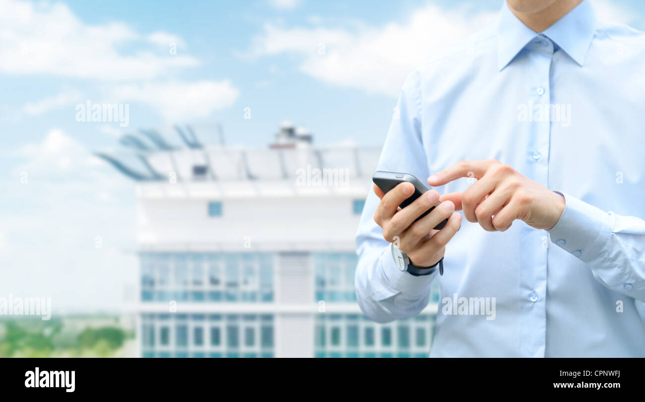 Man holding et toucher sur téléphone mobile avec l'arrière-plan flou sur la construction. Banque D'Images