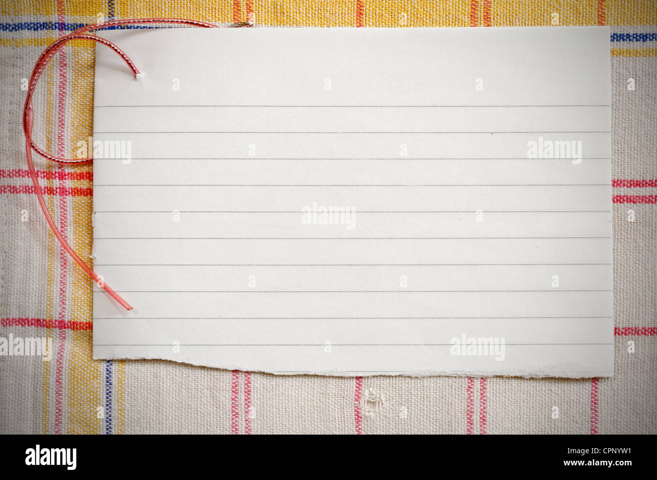 Papier déchiré avec le fil rouge sur la vieille nappe horizontale, vignetted shot Banque D'Images