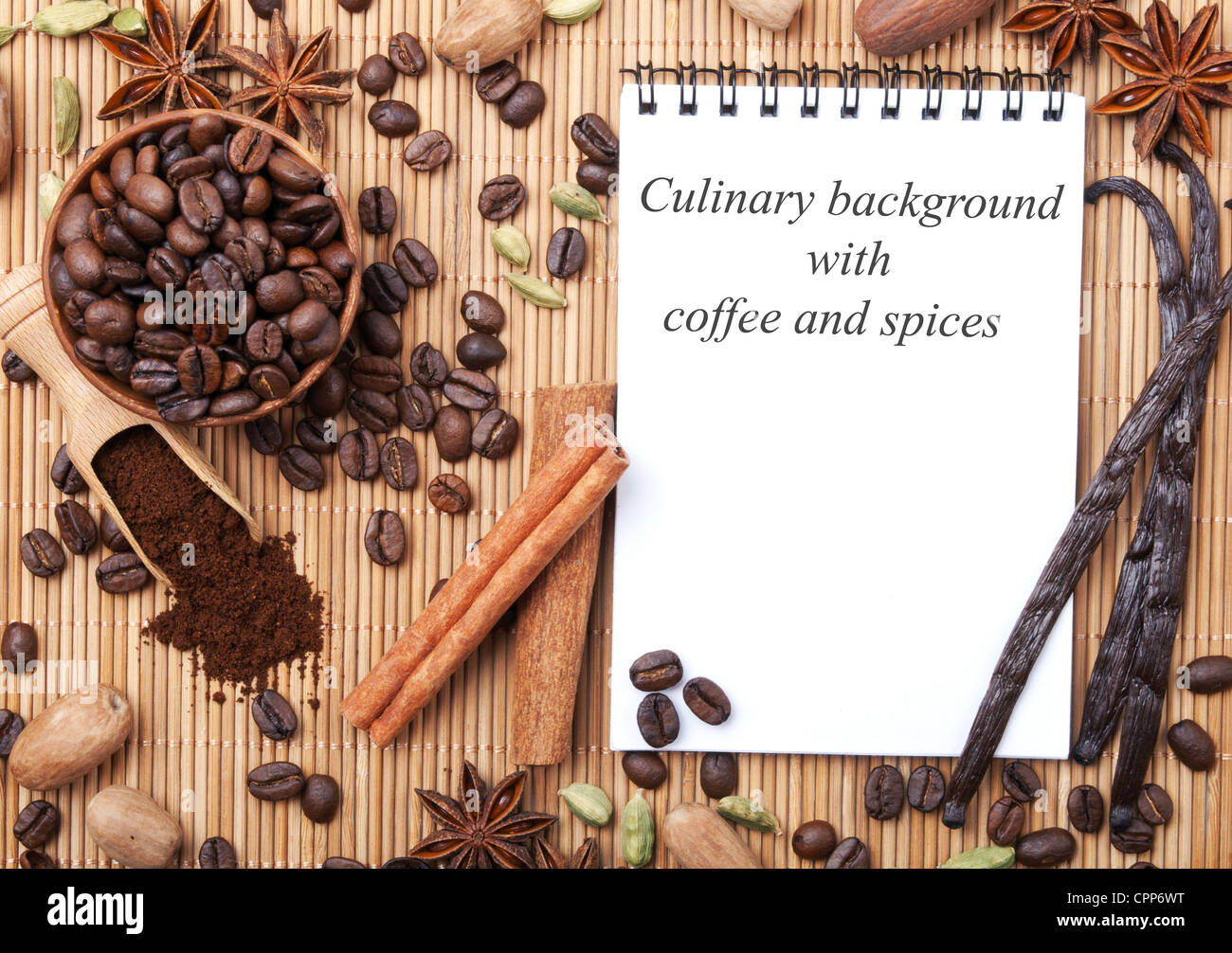 Ordinateur portable ouvert et différentes épices sur le tapis de bambou. Contexte culinaire Banque D'Images