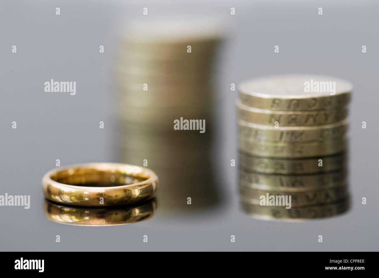 De l'argent avec anneau de mariage montrant concepts de l'accord prénuptial, liquidation, règlement de divorce, de pensions ou de planification pour l'avenir. Banque D'Images