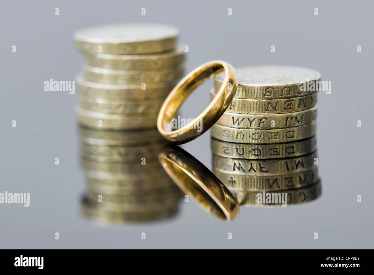 De l'argent avec anneau de mariage montrant concepts de l'accord prénuptial, liquidation, règlement de divorce, de pensions ou de planification pour l'avenir. Banque D'Images