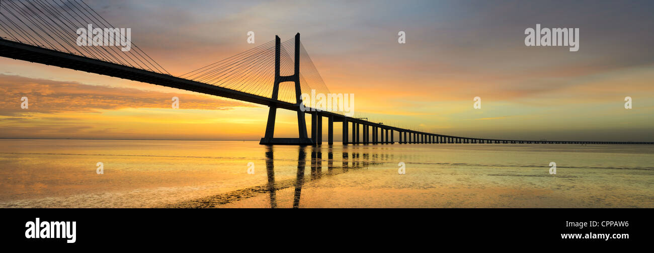 Photo panoramique du pont Vasco de Gama à Lisbonne, Portugal au lever du soleil, avec la réflexion dans le tage Banque D'Images