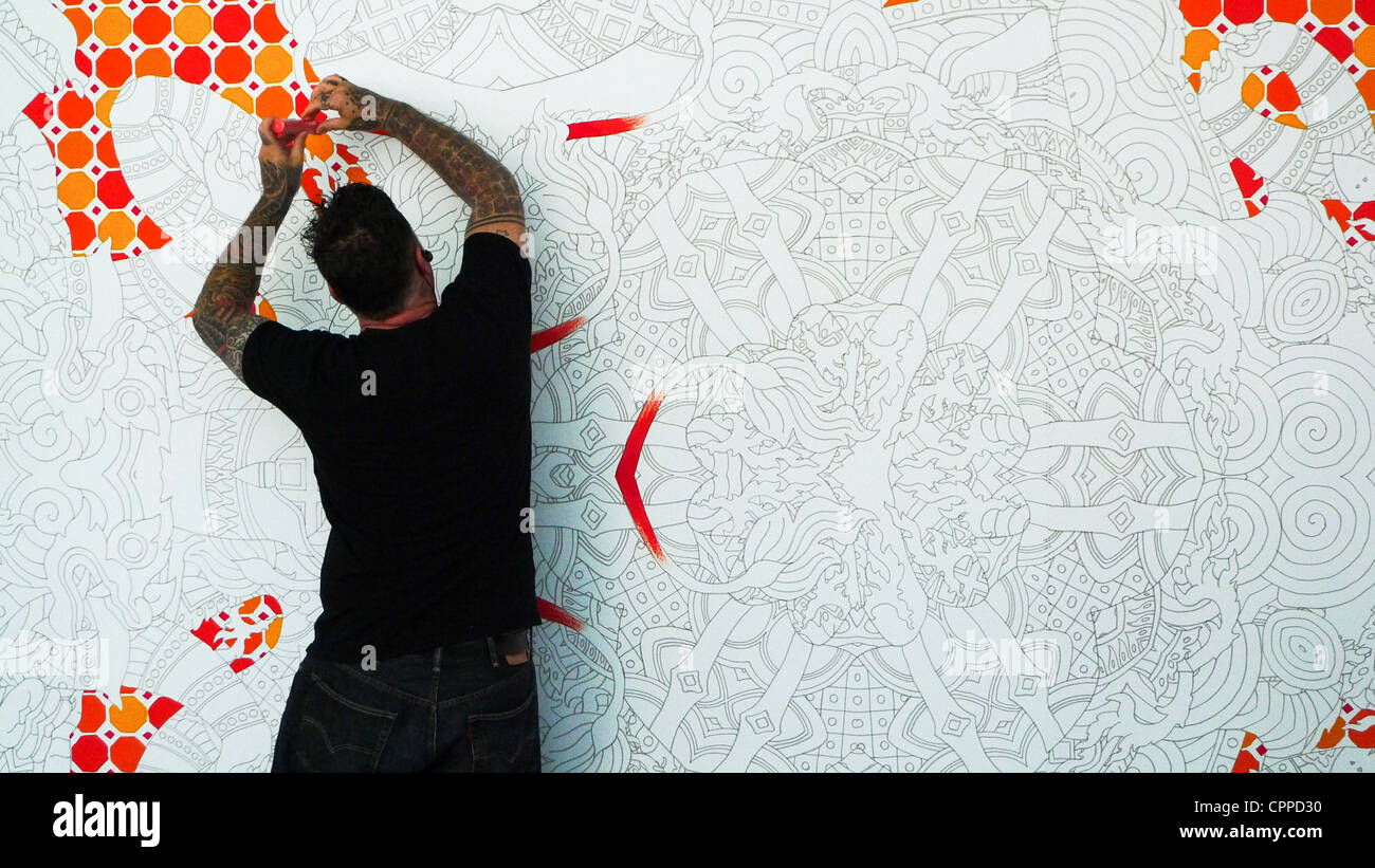 Joshua Davis artiste numérique s'appuyant sur une grande toile au Festival OFFF 2012 à Barcelone Banque D'Images
