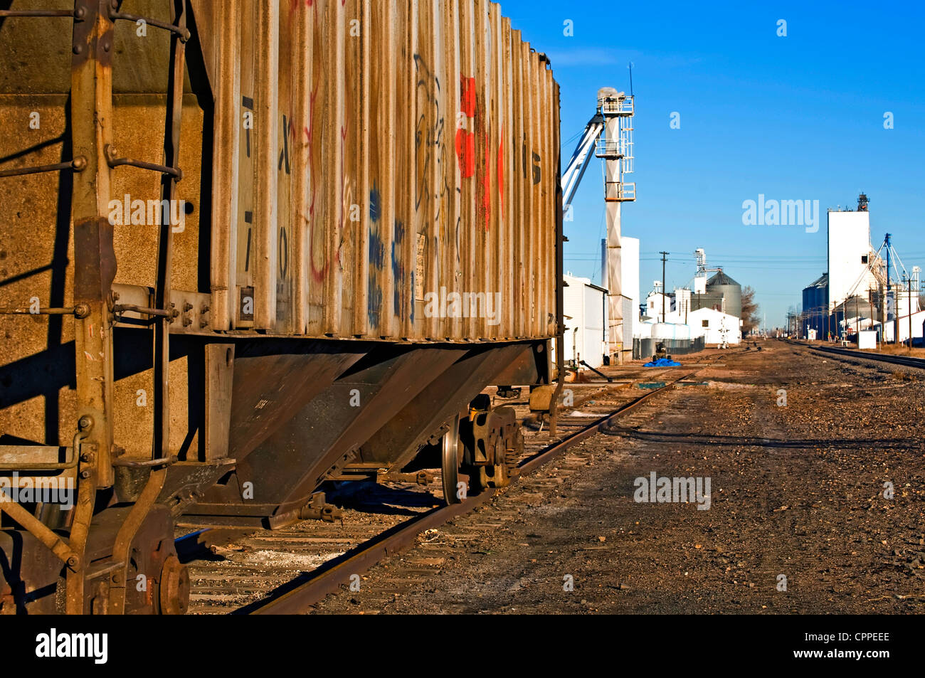 Scène tranquille d'un village rural avec une vieille voiture rouillée couverts de graffitis en attente sur une voie d'évitement. Banque D'Images