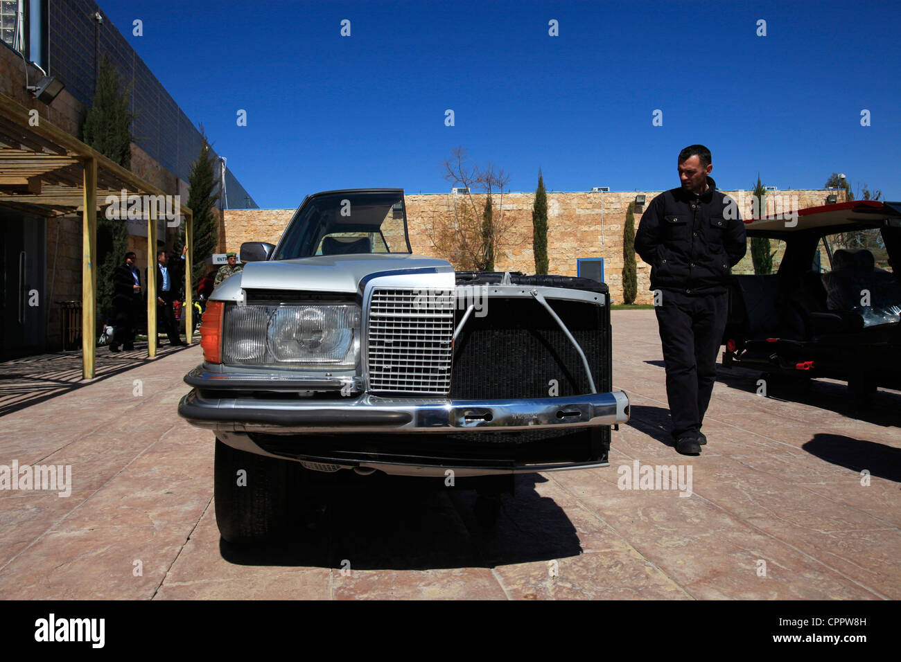 Un homme jordanien inspecte une ancienne installation de voiture Mercedes-Benz coupée en deux à l'entrée du musée royal de l'automobile dans le parc national d'Al Hussein. Amman Jordanie Banque D'Images