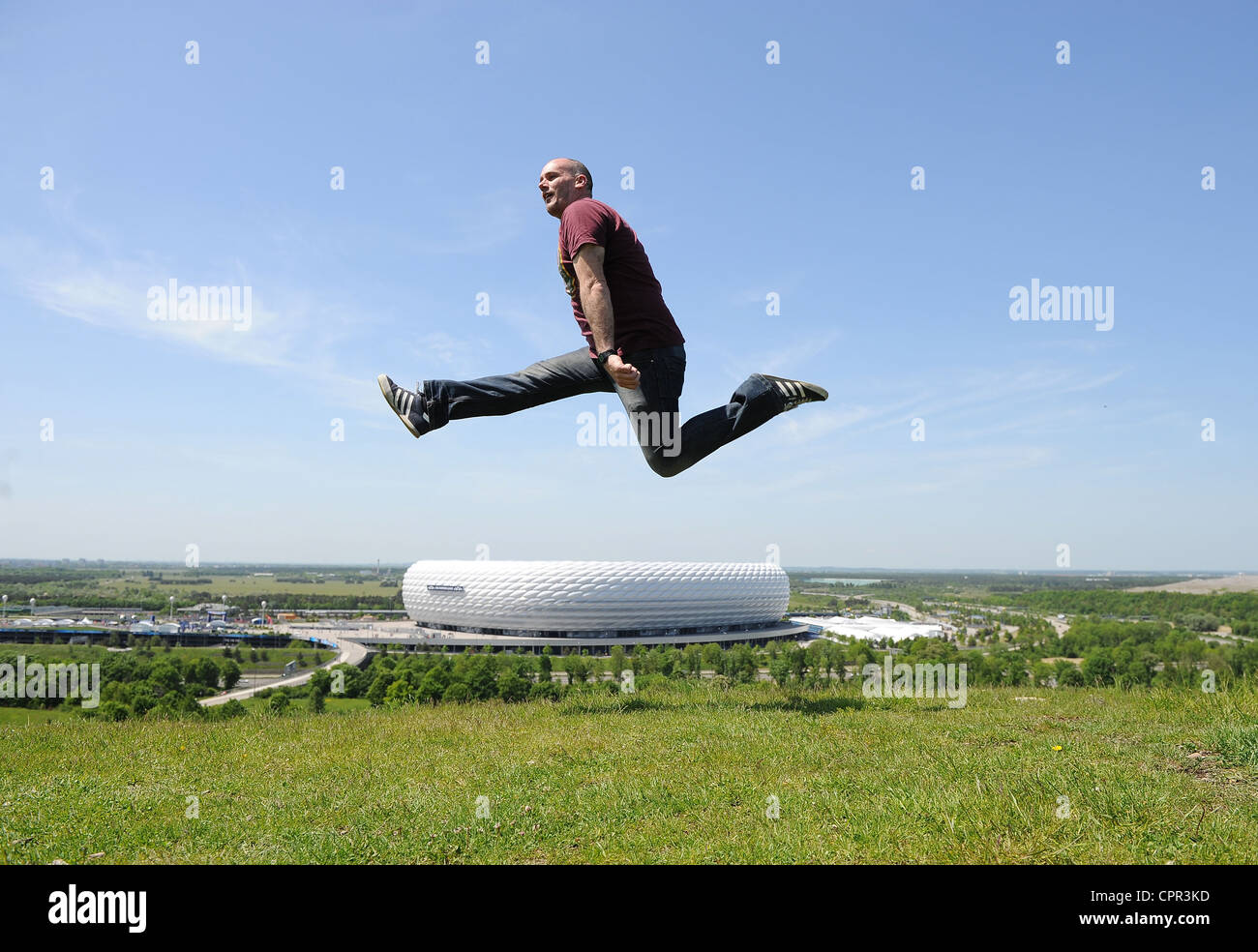 Un homme passe sur une colline surplombant l'Allianz Arena à Munich Banque D'Images