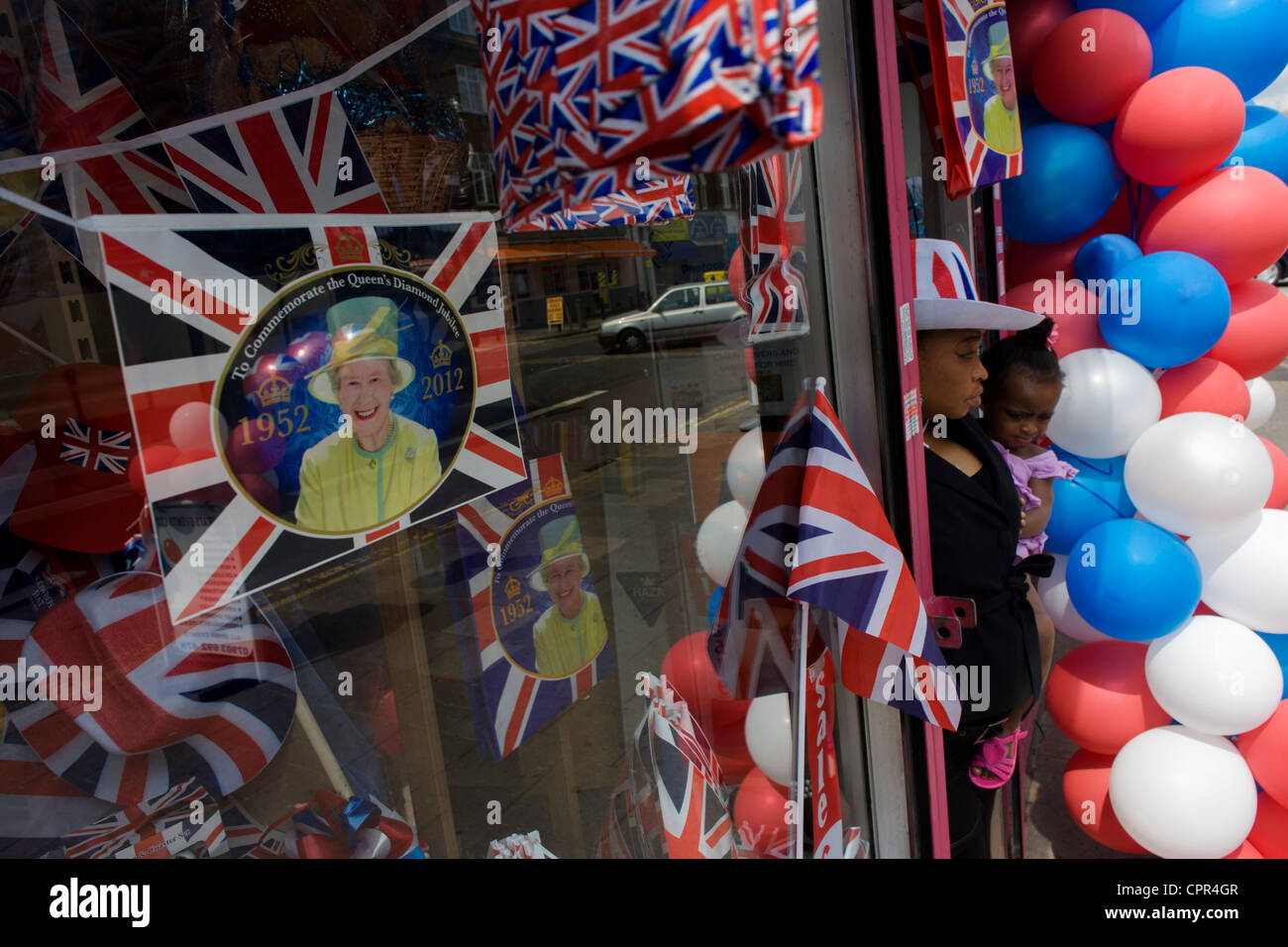 La mère et l'enfant avec patriotic bunting, drapeaux, ballons et royal souvenirs exposés avant le Jubilé de diamant de la Reine du sud de Londres dans une vitrine. Banque D'Images