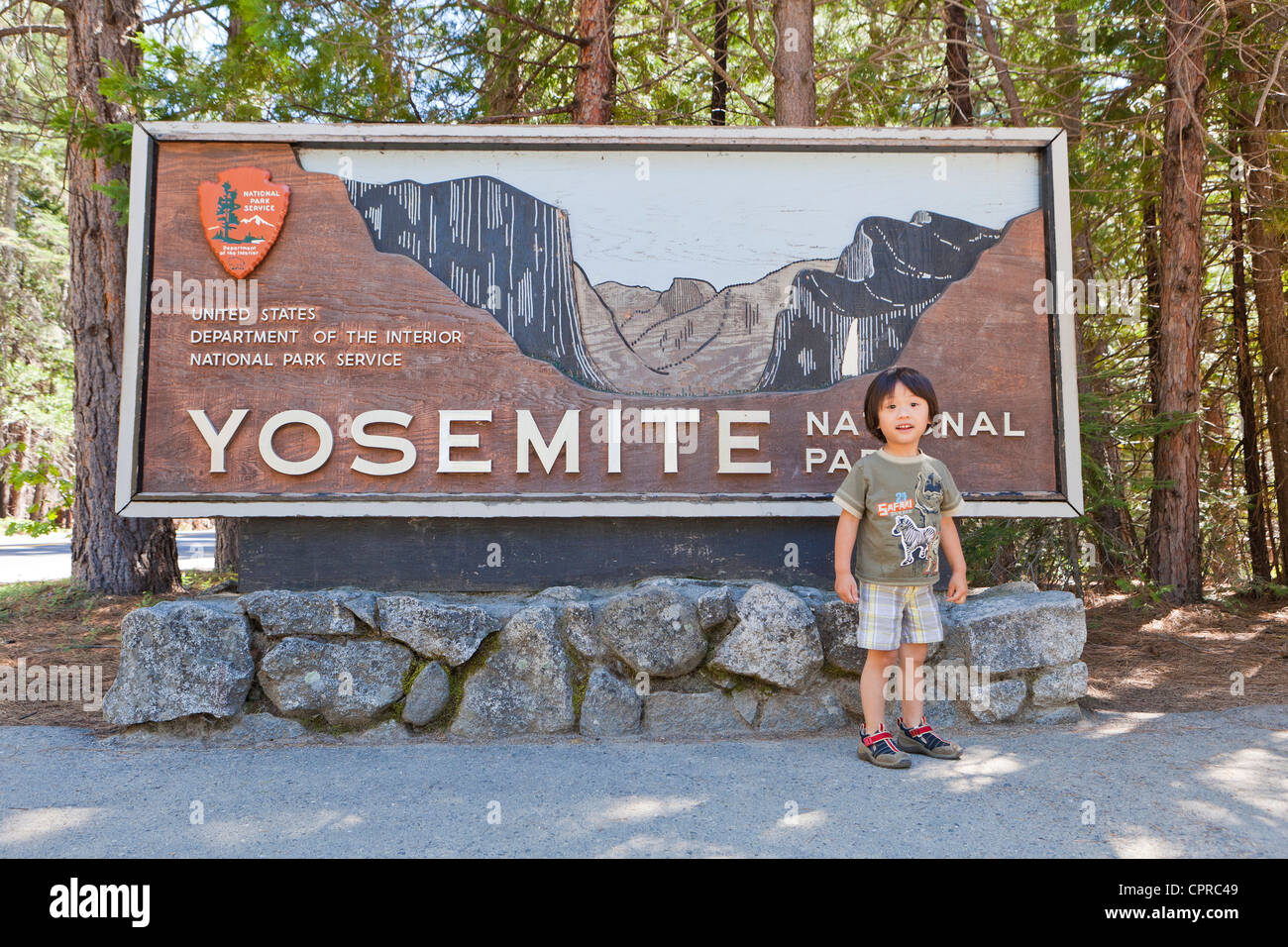 Un petit garçon asiatique en face de Yosemite National Park sign Banque D'Images