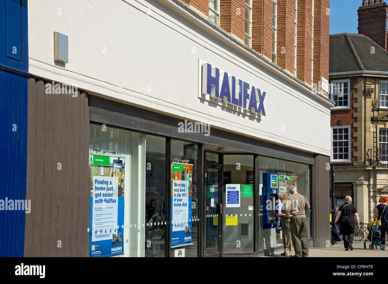 Des personnes âgées se coupent à un guichet automatique situé à l'extérieur de la banque Halifax York North Yorkshire Angleterre Royaume-Uni GB Grande-Bretagne Banque D'Images