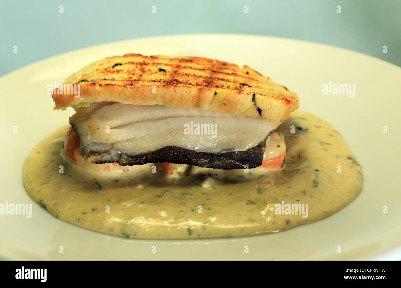 Un Filet de limande sole assise sur la baie de Galway avec une garniture de crevettes une tranche de pain grillé entouré d'une sauce crémeuse. Banque D'Images