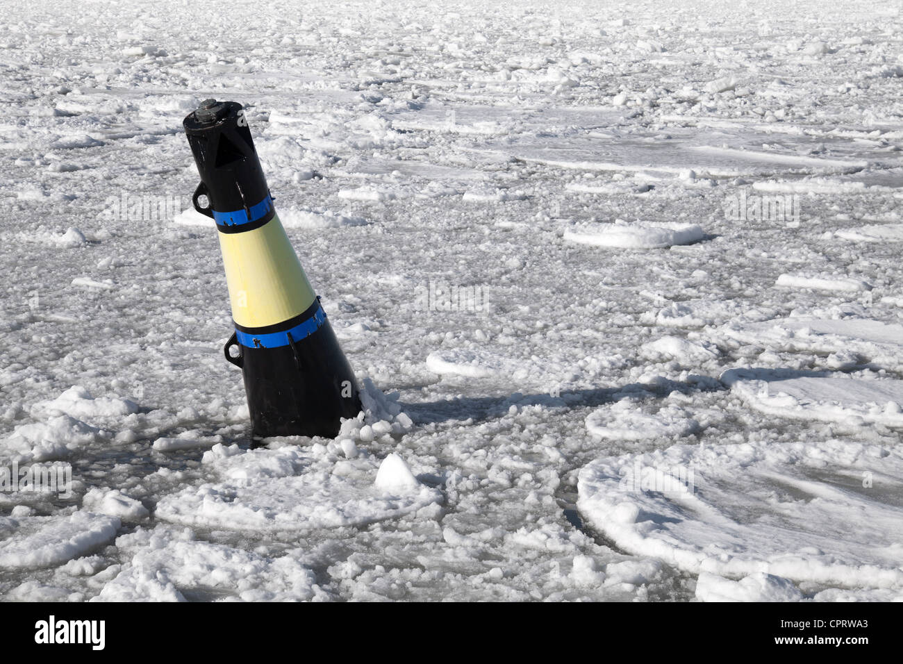 Bouée conique jaune et noir sur la mer Baltique gelée Banque D'Images