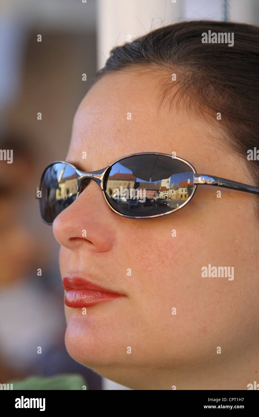 Portrait d'une femme portant des lunettes de soleil dans une vieille ville européenne traditionnelle.L'emplacement est en petit carré,Sibiu Roumanie Banque D'Images