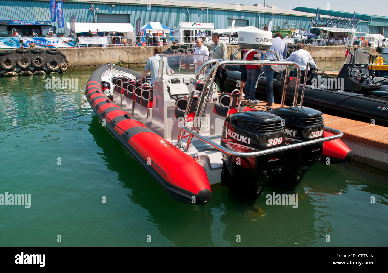 Un grand bateau gonflable rigide avec deux moteurs hors-bord, à flot le long d'une jetée. Banque D'Images