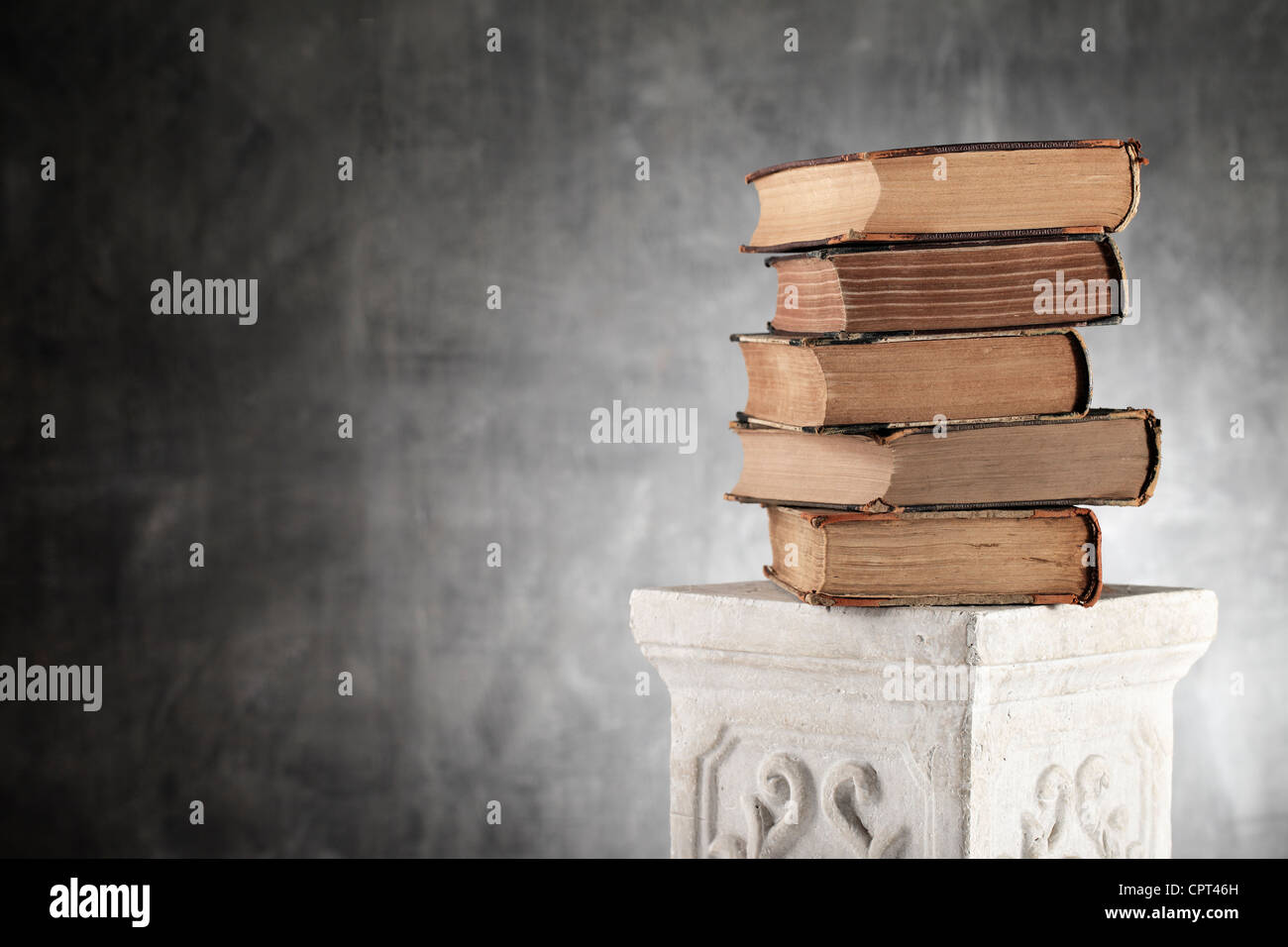 Pile de livres sur un papier jauni antique colonne en plâtre. Banque D'Images