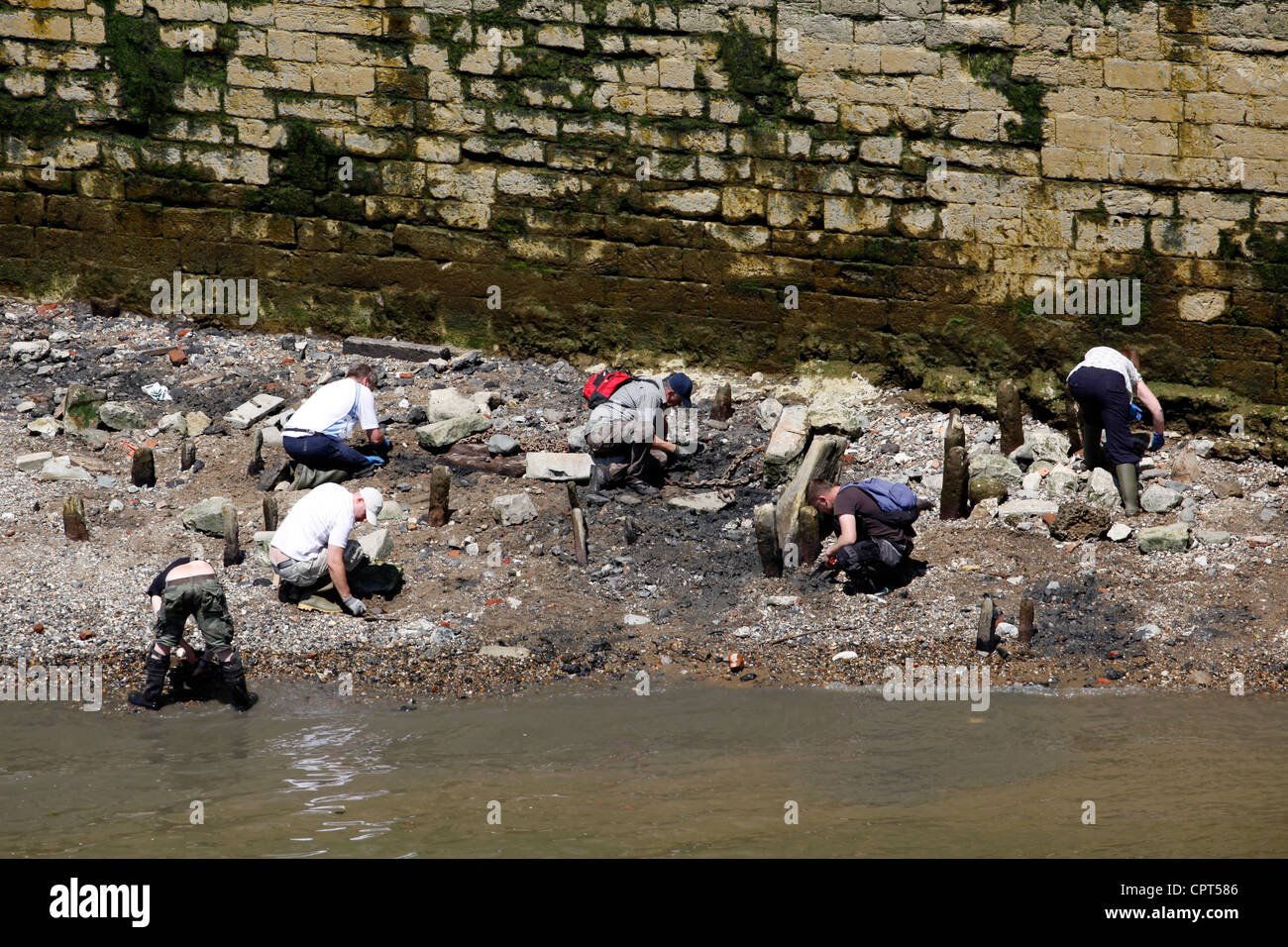 Tamise jour mudlarking avec les gens de l'archéologie et épaves dans la boue le long des rives de la Tamise par le Tower Bridge Banque D'Images