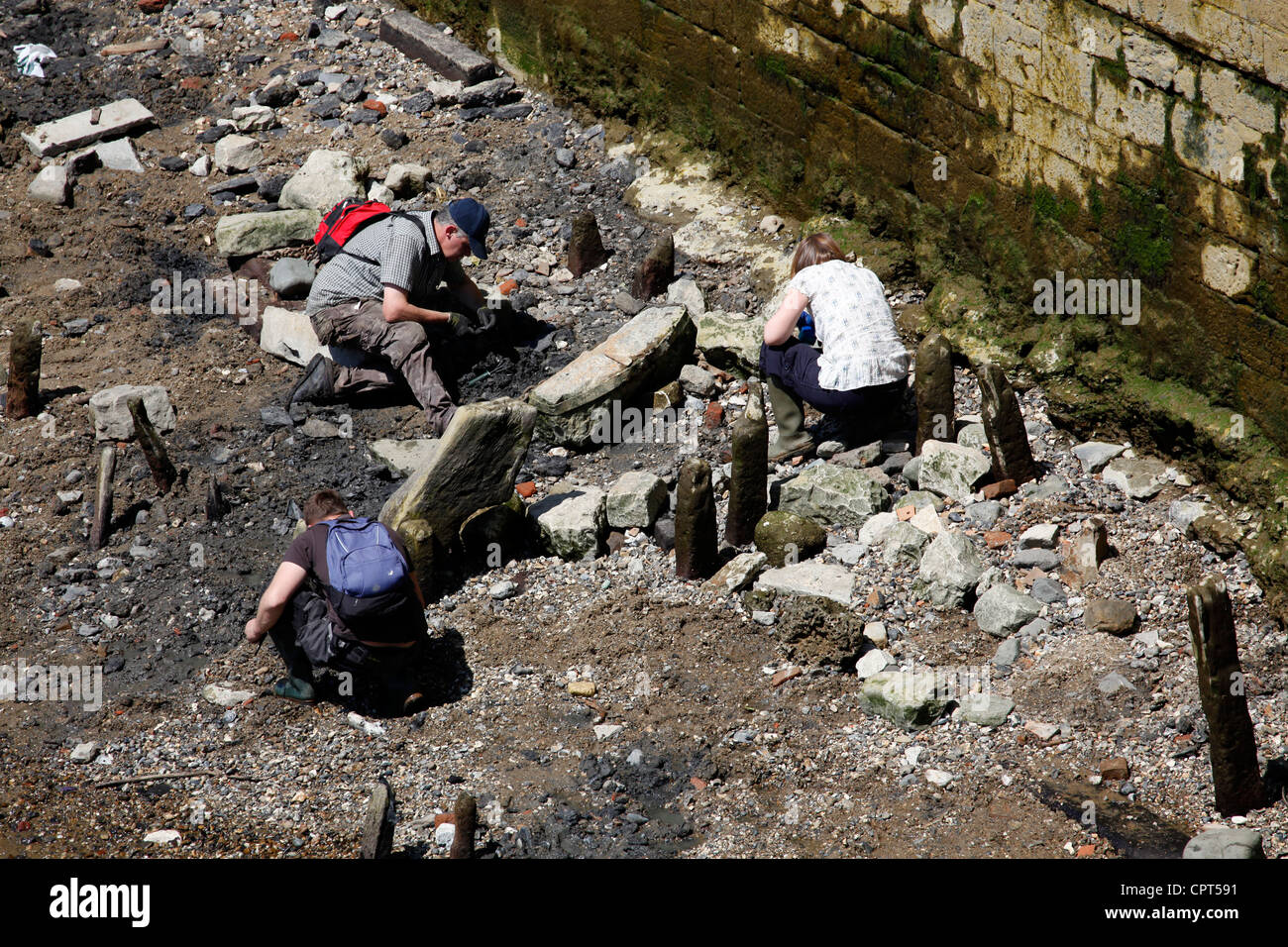 Tamise jour mudlarking avec les gens de l'archéologie et épaves dans la boue le long des rives de la Tamise par le Tower Bridge Banque D'Images